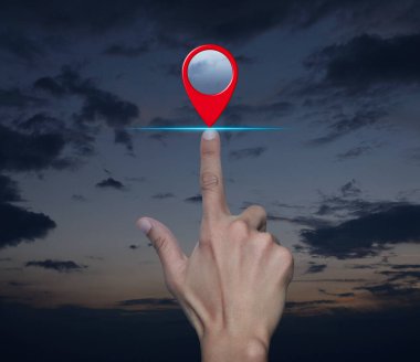 Gün batımı gökyüzü üzerinde el ile harita nokta konumlandırma düğmesi, harita işaretleyici navigasyon kavramı