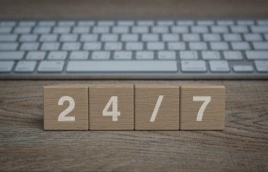 Ahşap blok küplerde modern bilgisayar klavyesiyle birlikte 247 harf, tam zamanlı iş hizmeti online konsepti