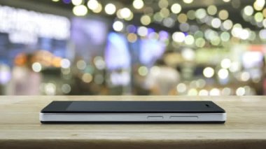 Hediye kutusu mutlu yeni yıl 2022 modern akıllı cep telefonu ekranındaki düz ikon bulanık ışık ve alışveriş merkezinin gölgesi üzerinde ahşap masa, iş yeni yılı mutlu yıllar 2022 çevrimiçi dükkan kavramı