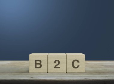 Tahta küpler üzerinde B2C kısaltması açık mavi gradyan üzerinde ahşap masa, müşteri pazarlama ve strateji konsepti iş