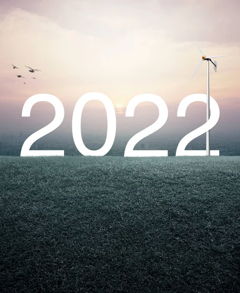 2022 Beyaz Metin Yeşil Çimen Tarlasında Rüzgar Türbini Ile Günbatımında — Stok fotoğraf