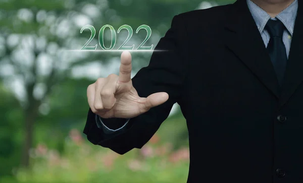 商人按下2022年的文字在公园里模糊的花和树 新年快乐 2022年日历封面概念 — 图库照片