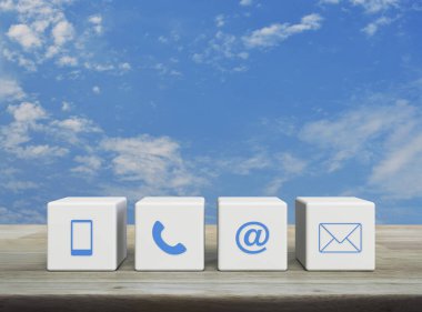 Cep telefonu, telefon, e-posta adresi ve posta simgesi beyaz blok küpleri üzerinde ahşap masa üzerinde beyaz bulutlar, iş müşteri hizmetleri ve çevrimiçi konsept desteği