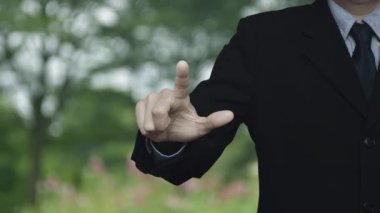 İş adamı parktaki bulanık çiçek ve ağaç üzerine e-posta resmi basıyor, İş dünyası bizimle çevrimiçi konsept üzerinden bağlantı kuruyor