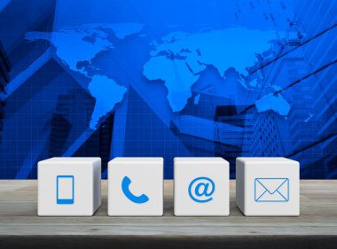 Cep telefonu, telefon, e-posta adresi ve posta simgesi beyaz blok küpleri üzerinde ahşap masa üzerinde dünya haritası, modern ofis kulesi ve gökdelen, iş dünyası müşteri hizmetleri ve çevrimiçi konsepti, NASA tarafından desteklenen bu görüntünün unsurları