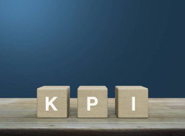 KPI harfi tahta küpler üzerinde açık mavi duvar üzerinde ahşap masa üzerinde, Anahtar Performans Göstergesi iş hedefi kavramı