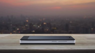 Güç düğmesi düz simgesi modern akıllı cep telefonu ekranı ahşap masa üzerinde şehir manzarası bulanık gün batımında, iş çevrimiçi konsept başlat