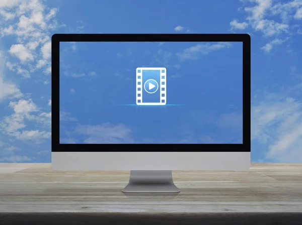 白い雲と青空の上に木製のテーブルの上にデスクトップ現代のコンピュータモニタ画面上のムービーフラットアイコンと再生ボタン ビジネス映画オンラインコンセプト — ストック写真