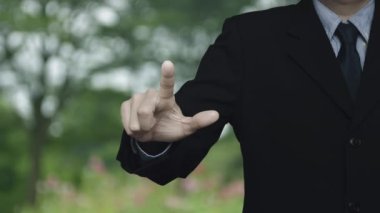 İş adamı, park, teknoloji güvenliği ve güvenlik online konsepti üzerindeki bulanık çiçek ve ağacın üzerine kamera resmi basıyor.