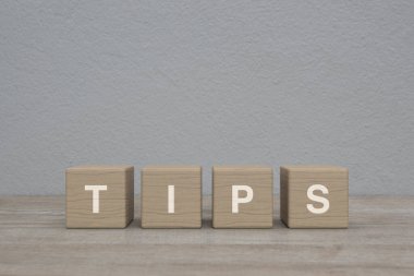 Tahta blok küplerdeki TIPS mektubu beyaz duvar arkaplanı, iş dünyası müşteri hizmetleri ve destek konsepti üzerindeki ahşap masa.