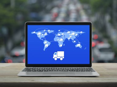 Bağlantı hattı ve dünya haritası olan bir kamyon ikonu modern dizüstü bilgisayar ekranında kalabalık saatte ahşap masa üzerinde arabalar ve yollar, iş ulaşımı online konsept, NASA tarafından desteklenen bu görüntünün elementleri