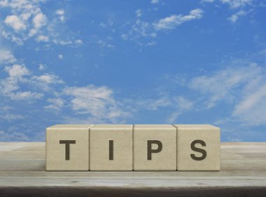 Tahta blok küplerdeki TIPS mektubu mavi gökyüzü üzerinde beyaz bulutlar, müşteri hizmetleri ve destek kavramı ile birlikte.