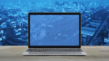 Modern dizüstü bilgisayar ekranındaki asma kilit simgesi ahşap masa üzerindeki şehir kulesi, sokak, gökdelen, teknoloji internet siber güvenlik ve güvenlik online konsepti üzerinde.