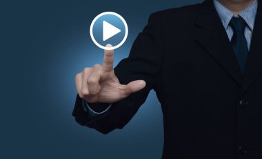 Businessman pressing play button icon over gradient light blue background, Business music online concept