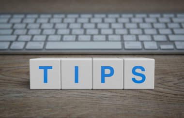 TiPS sözcüğü beyaz blok küpleri üzerinde modern bilgisayar klavyesi, müşteri hizmetleri ve çevrimiçi konsepti destekleyen ahşap masa üzerinde