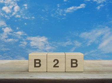 Tahta küpler üzerine B2B harfi beyaz bulutlu mavi gökyüzü üzerinde ahşap masa üzerinde iş pazarlama ve strateji konsepti