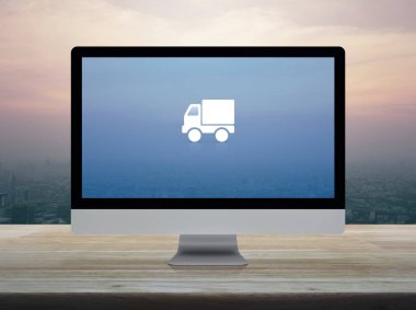 Masaüstü modern bilgisayar ekranında düz ikon dağıtım kamyonu şehir kulesinin üzerinde ahşap masa ve günbatımında gökdelen, klasik tarz, iş ulaşımı online konsept