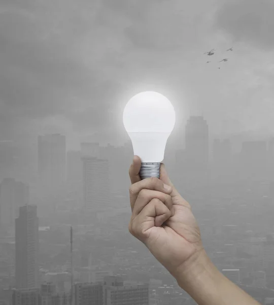 Hand Holding Led Light Bulb Pollution City Tower Birds Green — Stock Photo, Image