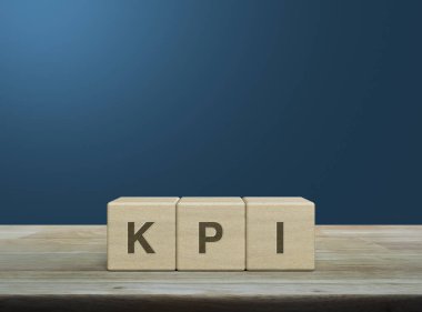 KPI letter on wood block cubes on wooden table over light blue gradient background, Key Performance Indicator business target concept