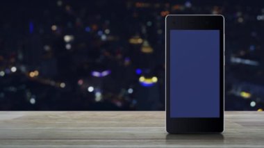 Motosiklet teslimatı düz simgesi modern akıllı cep telefonu ekranında ahşap masa üzerinde bulanık gece lambası şehir kulesi ve gökdelen, iş teslimatı online konsepti