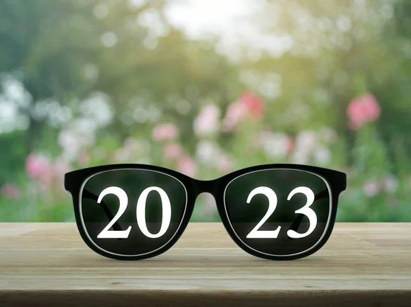 2023 White Text Black Eye Glasses Wooden Table Blur Pink — Stock Photo, Image