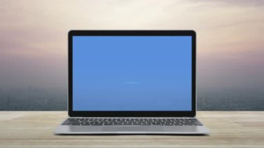 Power button icon on modern laptop computer screen on wooden table over city tower and skyscraper at sunset, vintage style, Business start up online concept