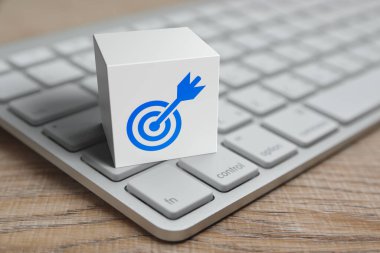 Dart düz ikonlu hedef beyaz blok küp üzerinde modern bilgisayar klavyesi ahşap masada, teknoloji başarısı online konsept
