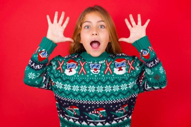 Noel süveteri giyen güzel bir kız kameraya heyecanla bakar, ellerini başının üstüne kaldırır, beklenmedik bir şey fark eder, ani haberlere tepki verir..