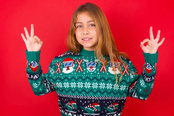 Feliz Hermosa Chica Con Suéter Navidad Muestra Signos Con Ambas — Foto de Stock