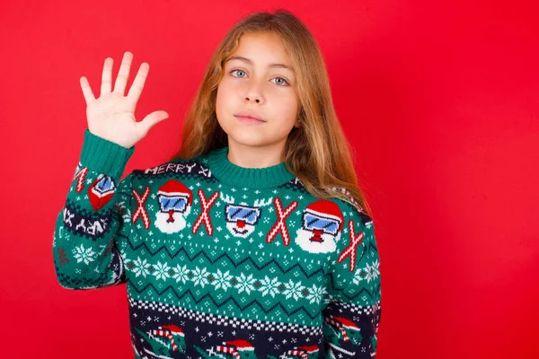 Gyönyörű Lány Visel Karácsonyi Pulóver Mutatja Rámutatva Ujjak Száma Miközben — Stock Fotó