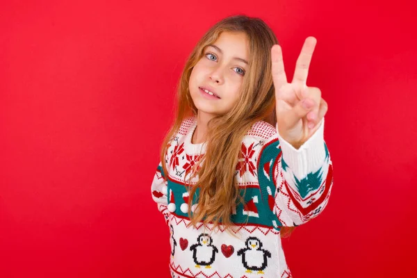 クリスマスのセーターを着ている美しい女の子は カメラで指を指示し 誰かを選択します 君を推薦する 最高の選択 — ストック写真
