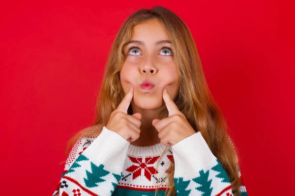 漂亮的女孩穿着圣诞毛衣 眼睛交叉 使鱼唇发笑 — 图库照片