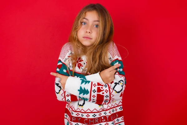 Beautiful Girl Wearing Sweater Crosses Arms Points Different Sides Hesitates — Stock Photo, Image