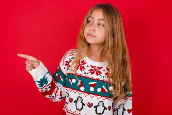 コピースペースでセーターポイントを着用し 何かを宣伝する美しい少女は 最高の価格をアドバイスします — ストック写真