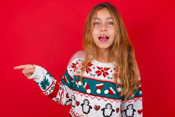 Hermosa Chica Vistiendo Suéter Ríe Felizmente Puntos Distancia Espacio Blanco — Foto de Stock