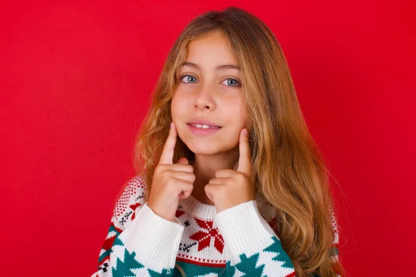 Glückliches Schönes Mädchen Trägt Pullover Mit Zahmem Lächeln Hält Zeigefinger — Stockfoto