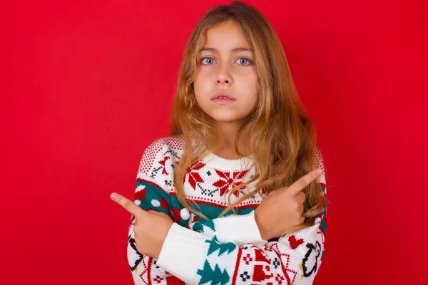 Alvorlig Smuk Pige Iført Sweater Krydser Hænder Peger Forskellige Sider - Stock-foto