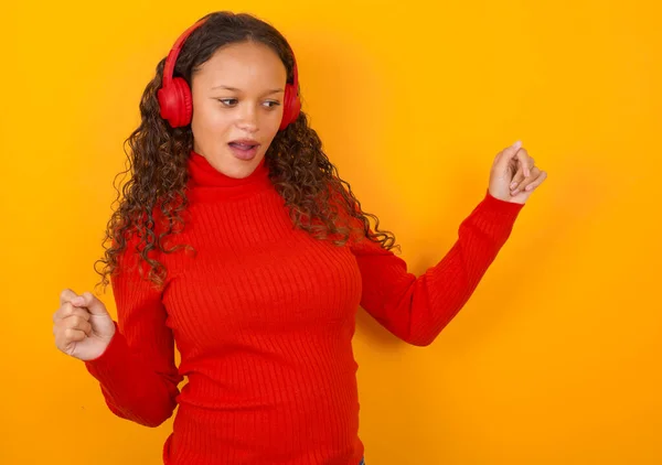 Mujer Vistiendo Suéter Rojo Pie Sobre Fondo Amarillo Bailando Escuchando — Foto de Stock