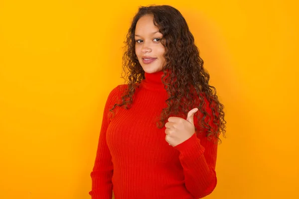 Woman Wearing Red Sweater Standing Yellow Background Giving Thumb Gesture — Stock Photo, Image