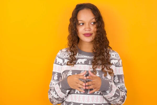 Woman Wearing Christmas Sweater Agaist Yellow Studio Background Steepls Fingers — Stock Photo, Image