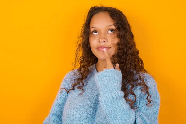 Lovely Dreamy Curly Woman Wearing Blue Sweater Yellow Studio Background — Stock Photo, Image
