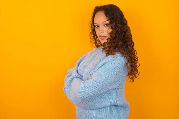 Portrait Curly Woman Wearing Blue Sweater Yellow Studio Background Standing — Stock Photo, Image