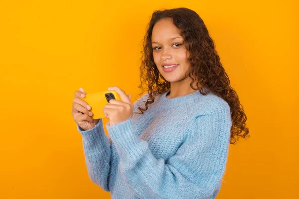 Nice Addicted Cheerful Curly Woman Wearing Blue Sweater Yellow Studio — Stock Photo, Image