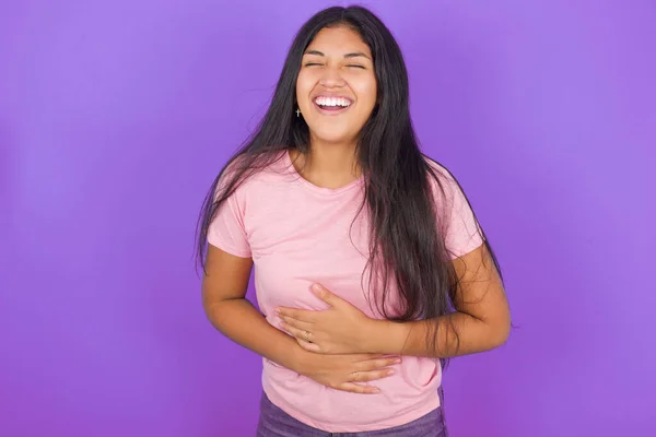Chica Morena Hispana Vistiendo Camiseta Rosa Sobre Fondo Púrpura Sonriendo —  Fotos de Stock