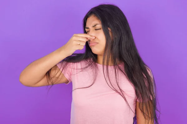 Chica Morena Hispana Con Camiseta Rosa Sobre Fondo Púrpura Oliendo —  Fotos de Stock