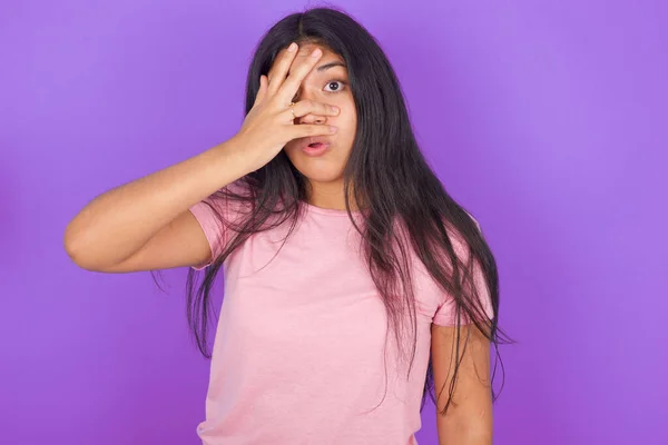 Menina Morena Hispânica Vestindo Camiseta Rosa Sobre Fundo Roxo Espreitando — Fotografia de Stock