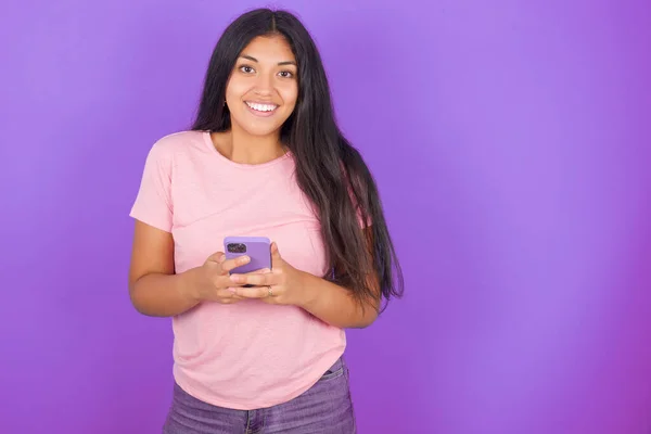 Emocionada Chica Morena Hispana Con Camiseta Rosa Sobre Fondo Púrpura —  Fotos de Stock