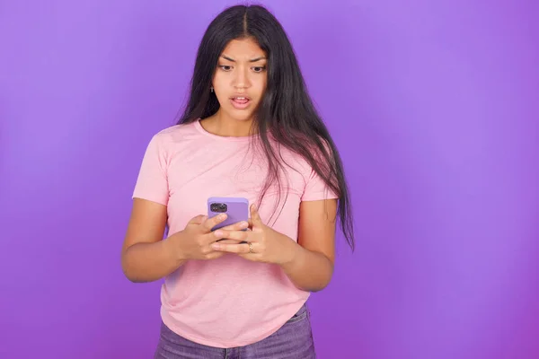 Focada Menina Morena Hispânica Vestindo Camiseta Rosa Sobre Fundo Roxo — Fotografia de Stock