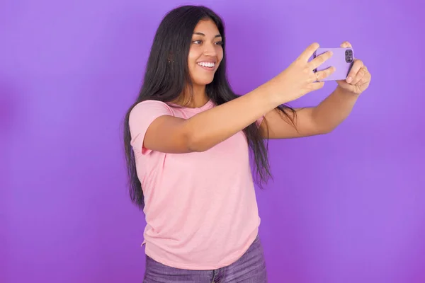 Chica Morena Hispana Con Camiseta Rosa Sobre Fondo Púrpura Tomando —  Fotos de Stock