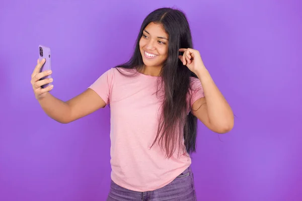 Chica Morena Hispana Vistiendo Camiseta Rosa Sobre Fondo Morado Sonriendo — Foto de Stock